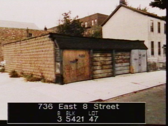 Surveying photo of a large ramshackle wooden garage on a residential street