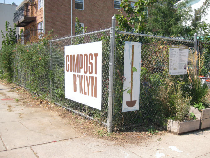 A fenced lot with greenery, trees, and a large sign labelled COMPOST B'KLYN